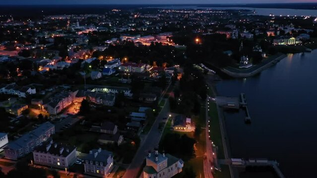 Picturesque aerial view of illuminated townscape of Uglich overlooking Kremlin cathedrals on banks of Volga River on summer twilight, Yaroslavl region, Russia. High quality 4k footage
