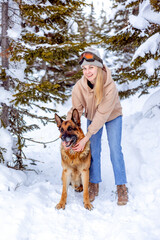 Dog with a woman in the winter forest. Traveling with a pet, a faithful companion.