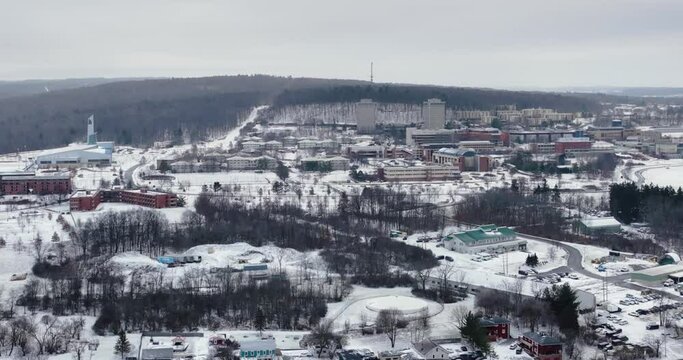 01-14-2023, Afternoon winter aerial video while snowing of the area surrounding the City of Ithaca, NY, USA, rising dolly in movement.