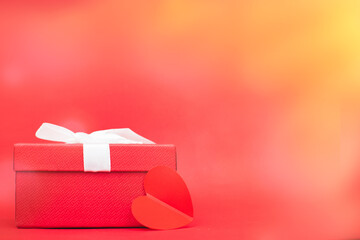 Present box with a heart on a red background.