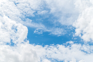 Naklejka premium Nature background from white clouds in sunny day. Beautiful white fluffy clouds in blue sky.