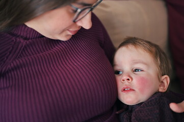 Mother comforts her sick little child