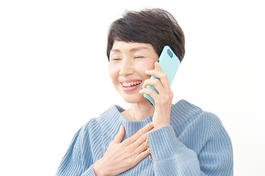 スマホで電話して安心する中年女性　白背景
