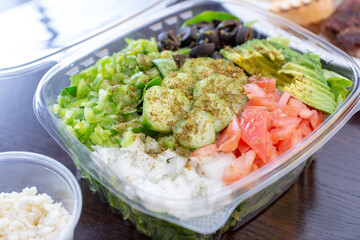 A view of a garden salad inside a clamshell plastic container.
