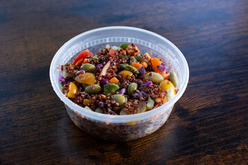A view of an Asian quinoa salad inside a plastic to go container.