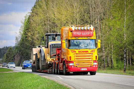 Colorful customized Scania G580 Truck Hauls Wheel Loader on Semi Trailer in Highway Traffic