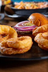 A view of an entree of hamburger and onion rings.