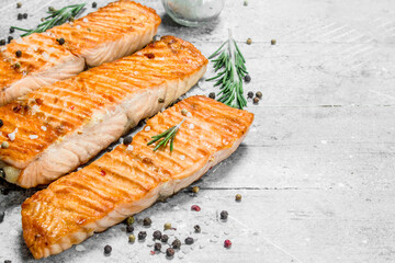 Grilled salmon fillet with spices and rosemary branches.