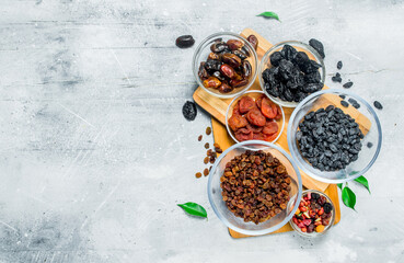 Assortment of different types of dried fruits in bowls.