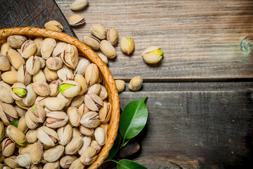 Pistachios in a basket with leaves.