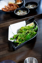 A view of a plate of shishito peppers.