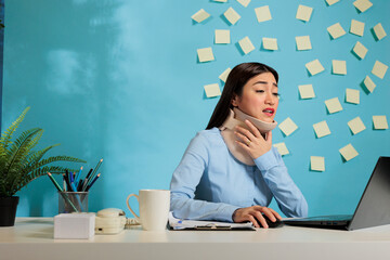 Asian woman wearing cervical collar to recover from injury. Office employee with fractured...