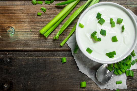 Fresh sour cream in bowl with green onions . - Powered by Adobe