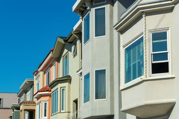 Row of decorative house facades or home exteriors in historic districts of San Francisco California neighborhood