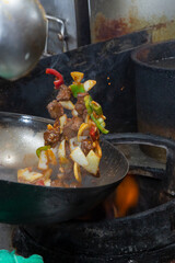 A view of a kitchen wok cooking shaken beef.