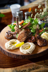 A view of a wood board platter of lamb chops.