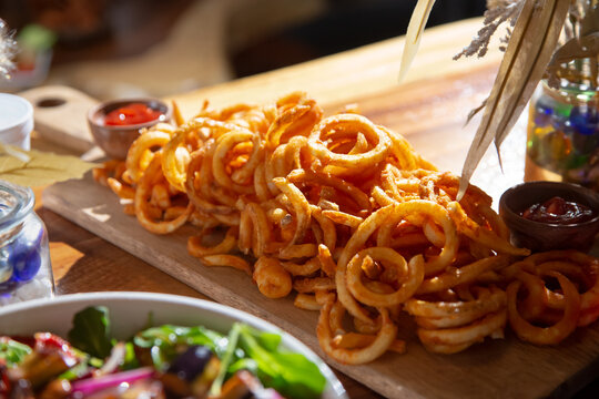 A view of a platter of curly fries.