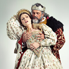 Theater, king and queen in costume with violence in in crown and renaissance clothes in studio....