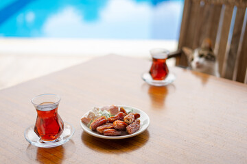 Dry Dates in a bowl and tea in armudu glass. Ramadan kareem.  Outdoor  background.