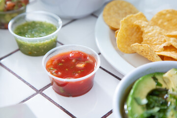 A view of a condiment cup of red salsa.