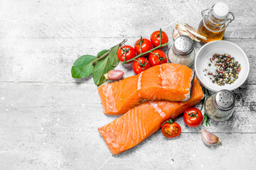 Raw salmon steaks with spices, herbs and olive oil.