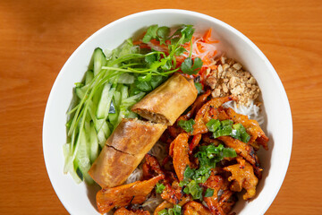 A top down view of a bowl of Vietnamese bun with marinated pork.