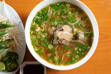 A top down view of a bowl of oxtail pho.
