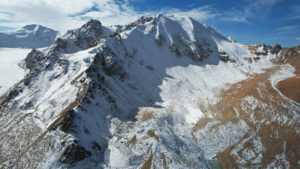 An ancient snow glacier among high mountains. The peaks of the mountains are covered with snow. In...