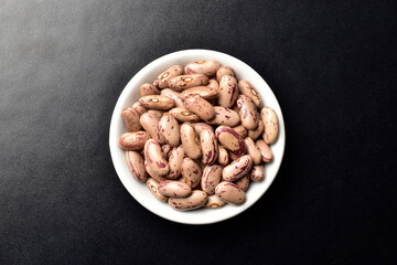 Raw pinto beans on dark background