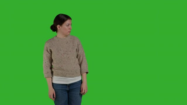 Front view of person showing refusal and pushing thing aside, expressing rejection and denial looking discontent. Female model acting displeased moving object, standing over greenscreen.