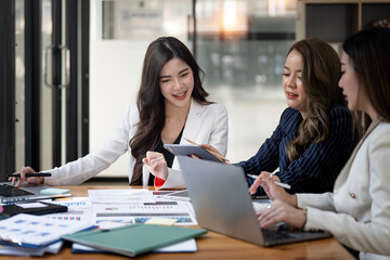 Group Of Businesswomen Collaborating In Creative Meeting Around Table In Modern Office