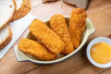 Fish fingers or fish sticks grilled, shallow deep-fried in dish on Table background ready to eat.