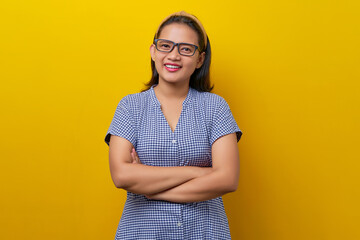 beautiful smiling young Asian woman wearing a dress checkered with glasses crossed hands and folded looking confident on camera isolated on yellow background. people lifestyle concept