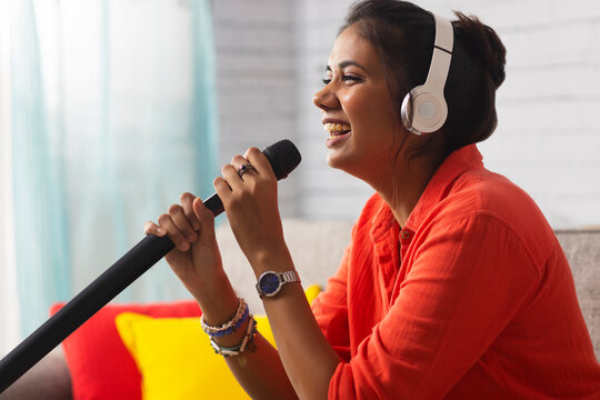 Close-up Portrait Of A Young Woman Singing At Home