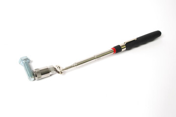 Magnet with a telescopic tube and a flashlight on a white background. A handy tool for car repair.