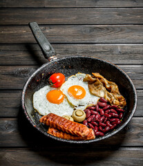 Traditional English Breakfast with fried eggs, sausages and beans.