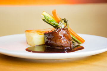 Grilled beef tenderloin with sauce and vegetables.