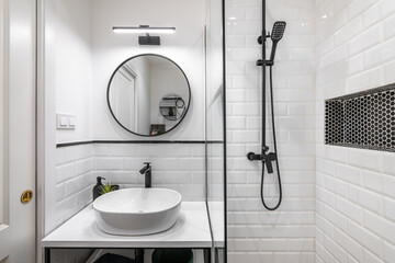 Modern bathroom in black and white style with high-quality expensive fittings. White brick walls...