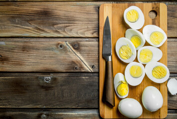 Sliced boiled eggs on cutting board.