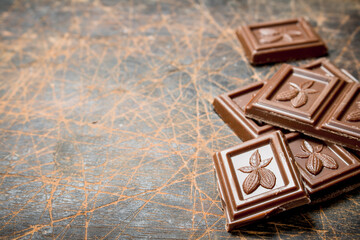Chocolate wedges on wooden background.