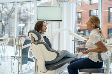 female dentist doctor and a female client are talking during a consultation in a dental clinic.