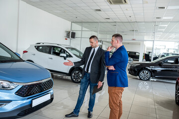 young male client choosing and buying car with help a professional sales agent