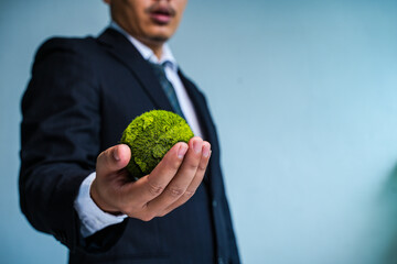 Earth Day. ESG Concepts in Environment, Society and Governance green energy Renewable and Sustainable Resources Caring for the environment and ecology Business hand holding a green globe. - obrazy, fototapety, plakaty
