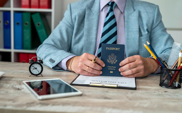 Close-up of male hands filling out visa documents at a table.