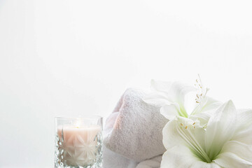 Close-up, lily flowers, candle and towel on a white background isolated.