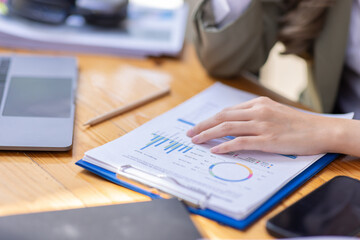 Close up of businesswoman Accounting using calculating income-expenditure and analyzing real estate investment data report Financial and tax systems concept.	