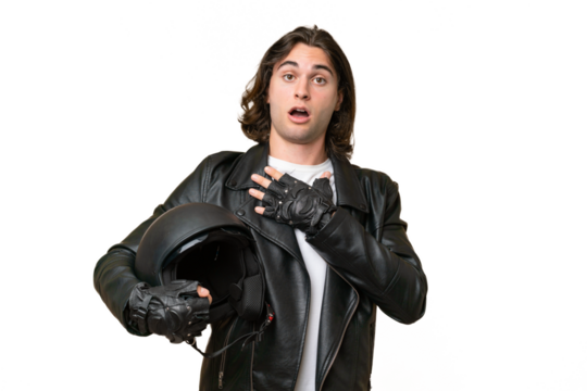 Young handsome man with a motorcycle helmet isolated on green chroma background surprised and shocked while looking right