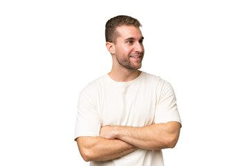 Young handsome caucasian man isolated on green chroma background looking to the side and smiling