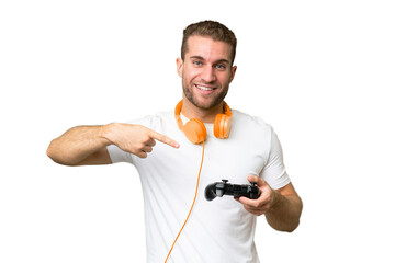 Young handsome man playing with a video game controller isolated on green chroma background and...