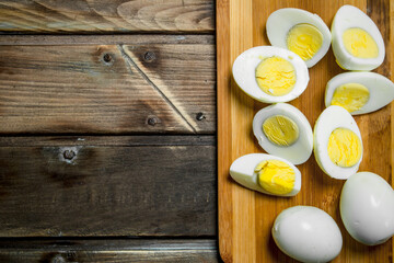Sliced boiled eggs on cutting board.